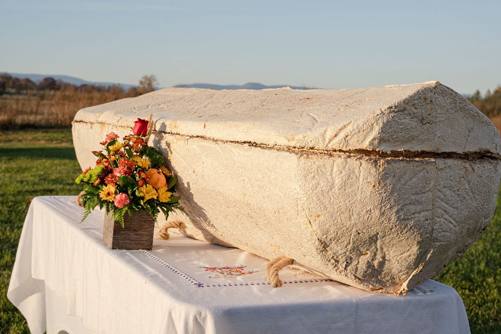 Mushroom Coffin with a floral arrangement on a table outdoors